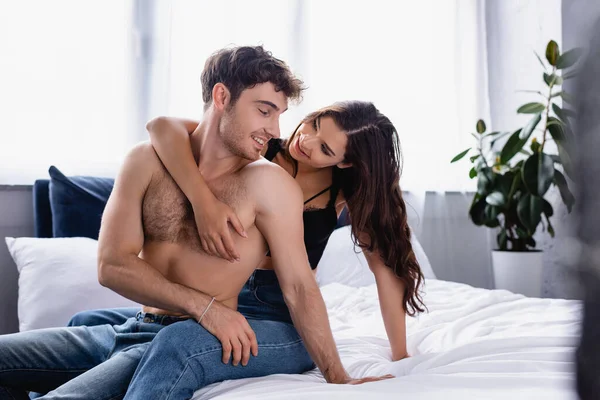 女人盯着躺在床上的赤身裸体男人看的选择性焦点 — 图库照片