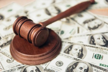 selective focus of wooden gavel near dollar banknotes  clipart