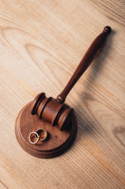 top view of golden rings on wooden gavel, divorce concept  clipart