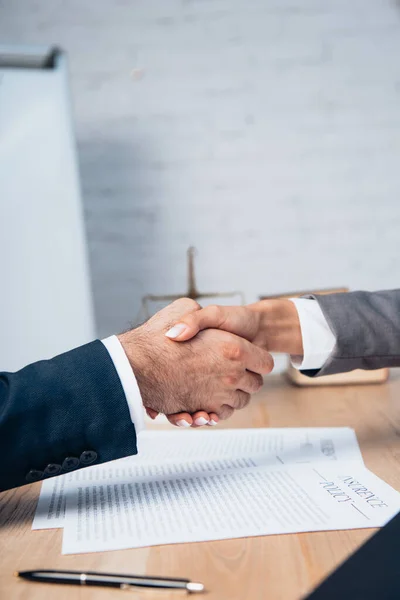 保険契約書の近くで握手をするビジネスマンやビジネスマンの — ストック写真