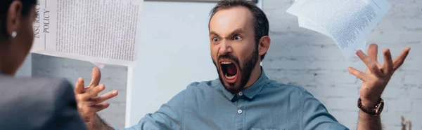 弁護士の近くで書類を投げながら怒りと髭の男が叫んでいるというパノラマの概念 — ストック写真
