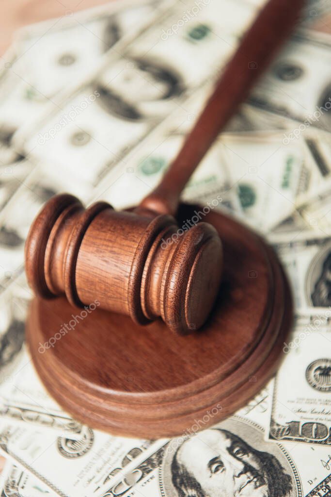 close up of wooden gavel near dollar banknotes 
