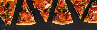 Sebzeli lezzetli İtalyan pizzaları ve siyah arka planda salam, panoramik çekim