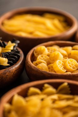 Tahta kaselerde çiğ fusilli ve döner makarnanın seçici odağı.