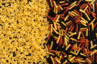 Çiğ renkli fusilli ve farfalle makarna üst görünümü