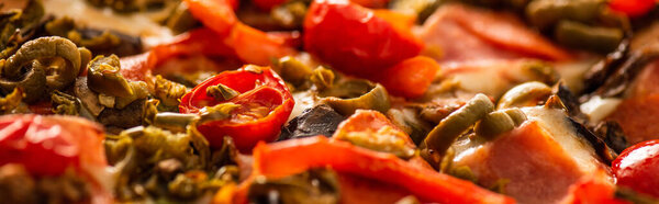 close up view of delicious Italian pizza with vegetables and salami, panoramic shot