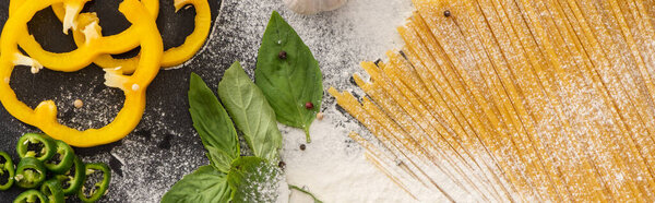 top view of raw spaghetti with vegetables, spices and flour, panoramic shot