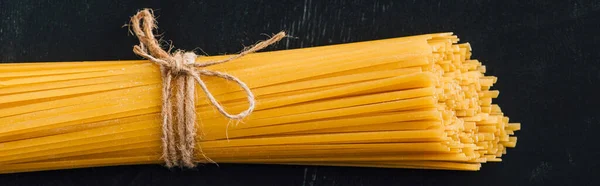 Top View Raw Italian Spaghetti Tied String Black Background Panoramic — Stock Photo, Image