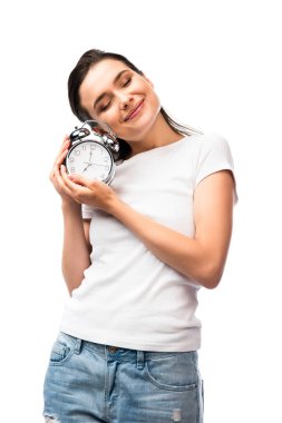 Beyaz tişörtlü, kapalı gözlü bir kadın. Elinde beyaz üzerinde retro alarm saati var.