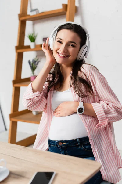 Enfoque Selectivo Mujer Embarazada Auriculares Inalámbricos Escuchando Música Cerca Teléfono —  Fotos de Stock