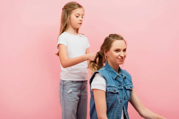 Chica Concentrada Camiseta Blanca Jeans Trenzando Pelo Madre Aislada Rosa —  Fotos de Stock