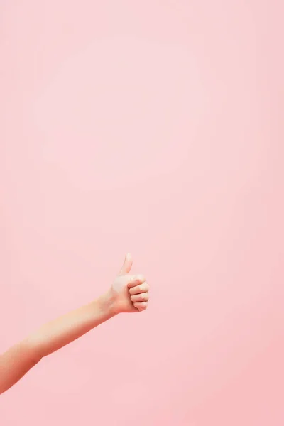 コピースペースでピンクに隔離された親指を示す子供の部分的なビュー — ストック写真