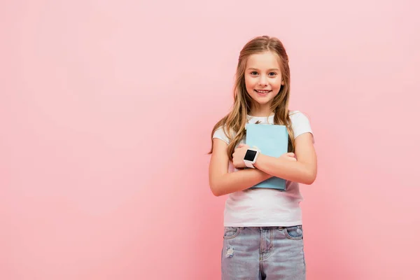 Παιδί Λευκό Shirt Και Smartwatch Κοιτάζοντας Κάμερα Ενώ Κρατώντας Βιβλίο — Φωτογραφία Αρχείου