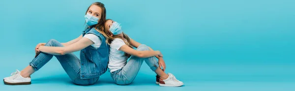 Kot Elbiseli Tıbbi Maskeli Kadın Çocuğun Arka Arkaya Mavi Üzerinde — Stok fotoğraf