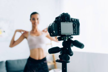 Dijital kameranın tripoda seçici odak noktası ve evde sporcu kadın eğitimi 