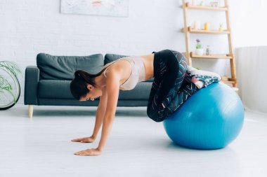 Spor salonundaki spor salonunda spor yapan esmer kadının yan görünüşü. 