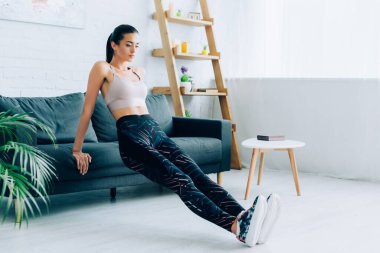 Oturma odasındaki kanepenin yanında spor yapan kadınların seçici odağı. 