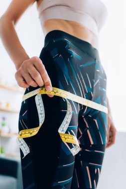 Formda sporcu kadının kalça ölçülerini evde bant ile ölçmesinin seçici odağı 