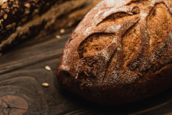 selective focus of fresh baked bread loaf on wooden surface