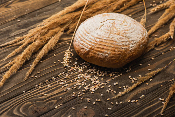 Свежий выпеченный белый хлеб с шипами на деревянной поверхности