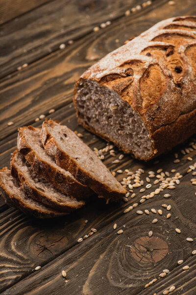 вырезать свежий хлеб с семенами на деревянной поверхности