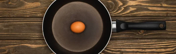 木制表面煎锅中生鸡蛋的顶视图 全景拍摄 — 图库照片