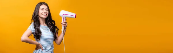 Mulher Morena Com Cachos Segurando Secador Cabelo Isolado Amarelo Tiro — Fotografia de Stock