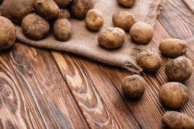 Tahta masada kirli patates ve çuval bezi.
