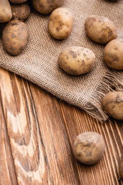 Tahta masada kirli patates ve çuval bezi.