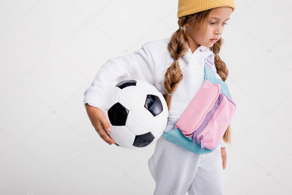 blonde girl in sportswear with soccer ball isolated on white