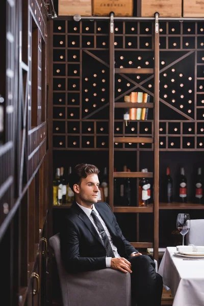Επιλεκτική Εστίαση Του Νεαρού Άνδρα Κοστούμι Κάθεται Κοντά Ποτήρι Κρασί — Φωτογραφία Αρχείου