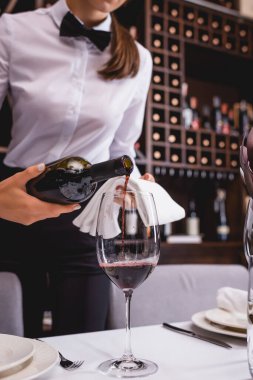Resmi şarap garsonunun görüntüsü. Şarap koyarken havlu takıyor. 