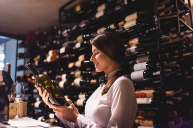 Restoranda şarap şişesi tutan şarap garsonunun seçici odağı. 