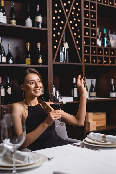 Selective Focus Young Woman Waving Hand While Holding Glass Wine — Stock Photo, Image