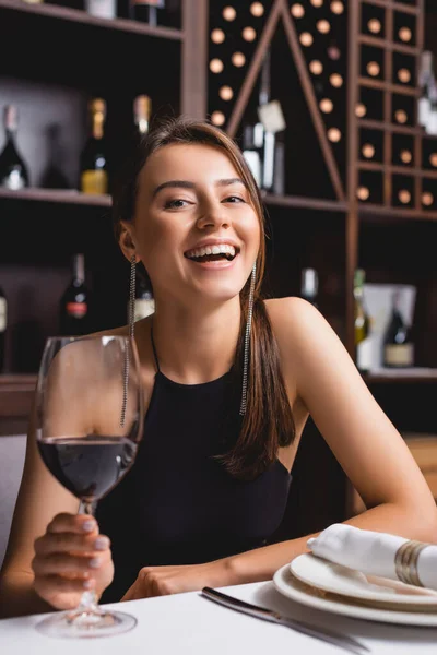 Enfoque Selectivo Mujer Emocionada Sosteniendo Vaso Vino Mientras Mira Cámara —  Fotos de Stock