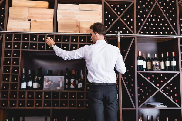 Zadní Pohled Sommelier Formálním Opotřebení Lahví Vína Regálu Restauraci — Stock fotografie