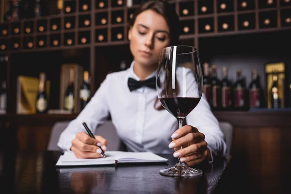Selective Focus Sommelier Holding Glass Wine While Writing Notebook Table — Stock Photo, Image