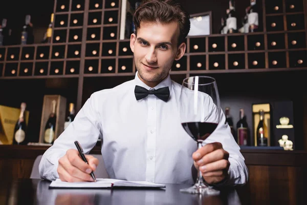 Selective Focus Sommelier Looking Camera While Holding Glass Wine Writing — Stock Photo, Image