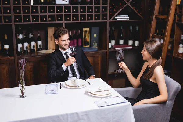 Casal Jovem Olhando Para Outro Enquanto Segurando Copos Vinho Restaurante — Fotografia de Stock