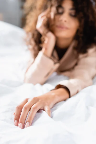 躺在床上摸白色被褥的年轻妇女的选择性焦点 — 图库照片