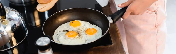 Cropped View Woman Holding Kitchen Tongs Eggs Frying Pan Panoramic — Stock Photo, Image