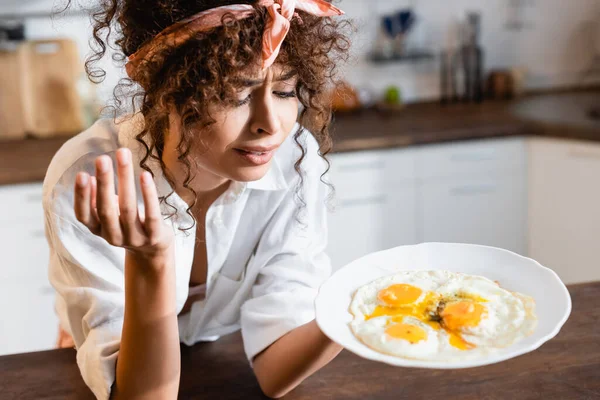 Confused Woman Looking Plate Fried Eggs Kitchen — Stock Photo, Image