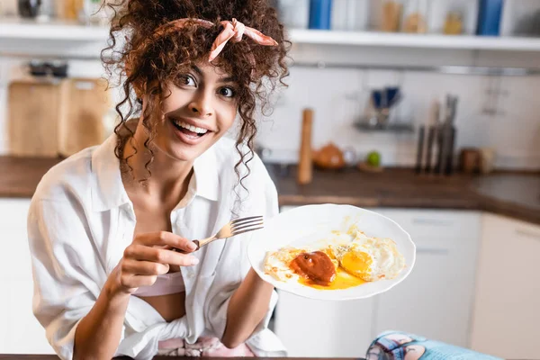 Excited Curly Woman Looking Camera While Holding Plate Fried Eggs — Stock Photo, Image