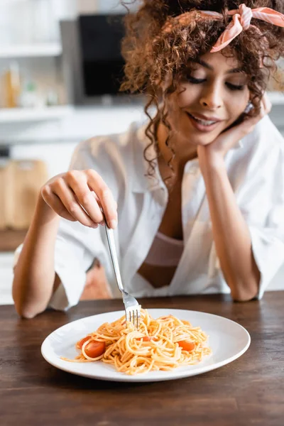 用意されたスパゲティでプレートの近くにフォークを持っている楽しい女性の選択的な焦点 — ストック写真