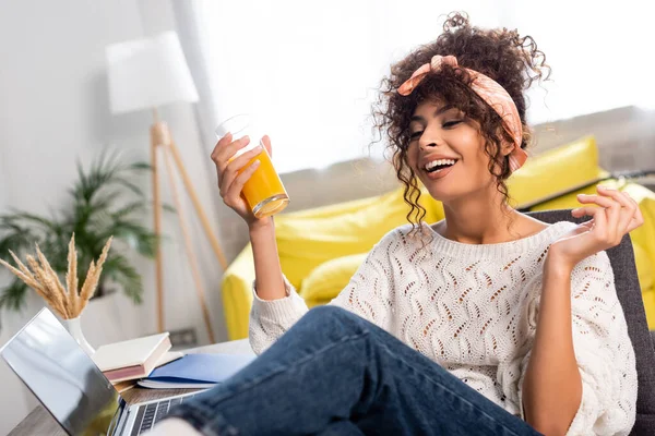 Mujer Complacida Sosteniendo Vaso Jugo Naranja Cerca Del Ordenador Portátil — Foto de Stock