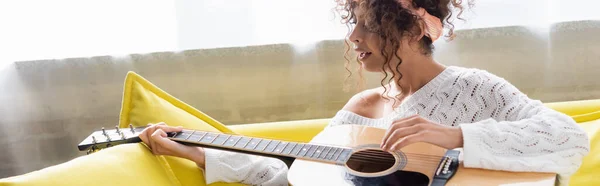 Panoramisch Schot Van Krullende Vrouw Spelen Akoestische Gitaar Zingen Woonkamer — Stockfoto