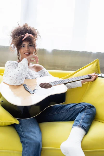 Mulher Alegre Segurando Guitarra Acústica Sentado Sofá Sala Estar — Fotografia de Stock