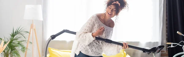 Panoramic Shot Curly Woman Having Fun While Holding Vacuum Cleaner — Stock Photo, Image