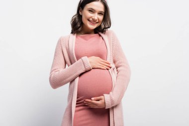joyful pregnant woman touching belly on white clipart