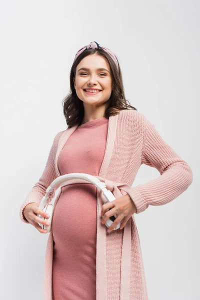 孕妇手持无线耳机 靠近腹部 与白色隔离 — 图库照片